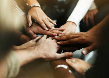 closeup of diverse people joining their hands