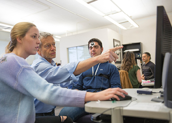 teacher talk with students while point at computer screen