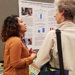 two women talking in front of a poster presentation