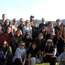 group of student gather together for a picture on top of a hill