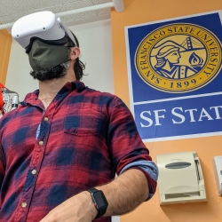 A research assistant wearing a VR headset at a SF State lab