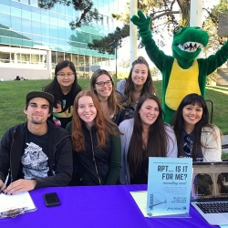 student sitting at a table outside