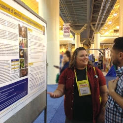 Rachelle Wilson explaining her poster content to a person.