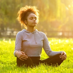 African American women meditating outside